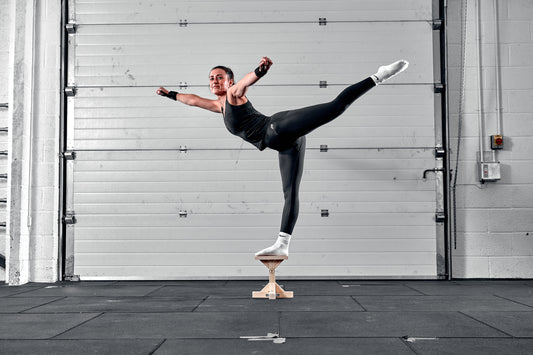 Gymnast balancing on stunt stand