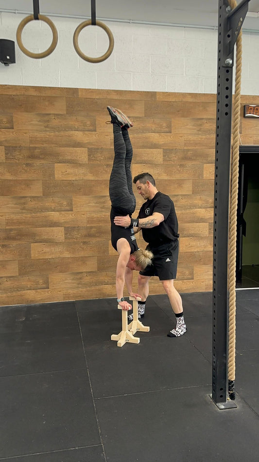 woman doing assisted handstand